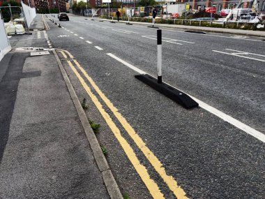 Salford, İngiltere - 12 Eylül 2025: Sakin bir günde yol işaretleri ve trafik engellerinin yer aldığı bir Salford şehri caddesi