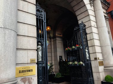 Manchester, İngiltere - 14 Eylül 2025: Detaylı demir kapılar ve taş mimari içeren Manchester 'da zarif bir otel girişi.