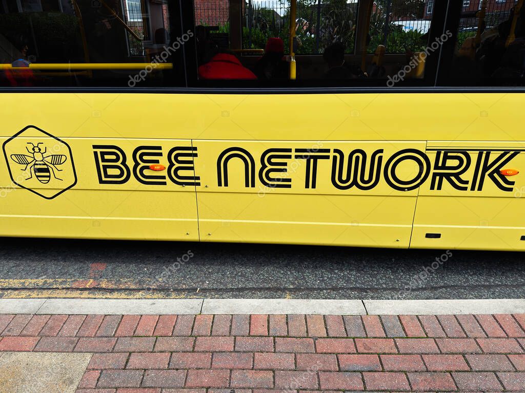 Manchester, UK - September 12, 2025: Yellow branded bus parked on roadside in Greater Manchester showcasing Bee Network design.
