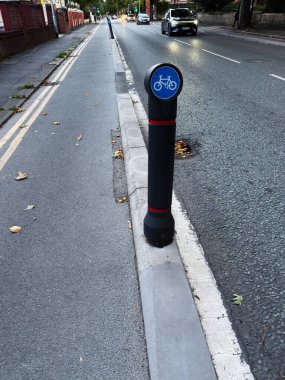 Manchester, İngiltere 'de gece aydınlatmasının altında cadde boyunca bisiklet yolu.
