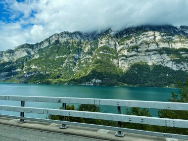 Turkuaz göl, dağ zeminiyle ve bulutlu gökyüzü İsviçre 'nin sakin doğasıyla yakalandı..