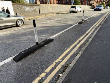 Salford, İngiltere - 16 Eylül 2025: İngiltere 'de şerit ayırıcıları, arabaları ve kaldırımları manzaralı trafik caddesi