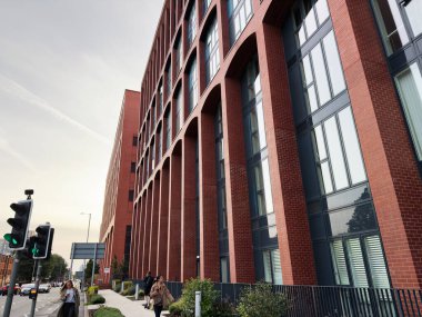 Manchester, İngiltere - 16 Eylül 2025: Manchester 'da yaya ve sokak trafiği bulunan kırmızı tuğla ofis binası