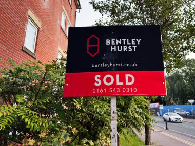 Manchester, İngiltere - 16 Eylül 2025: Bentley Hurst, çevrede yeşillik olan bir binanın yakınında sergilenen bir tabela sattı.