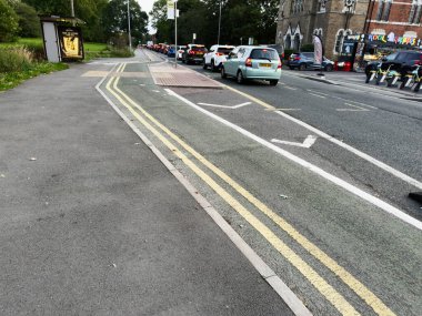 Manchester, İngiltere - 16 Eylül 2025: Manchester, İngiltere 'de park halindeki araçlar ve bisiklet şeridiyle dolu yol sahnesi