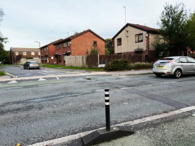Manchester, İngiltere - 16 Eylül 2025: Manchester 'da sakin bir banliyö caddesi park halindeki araçları ve konutları gösteriyor.