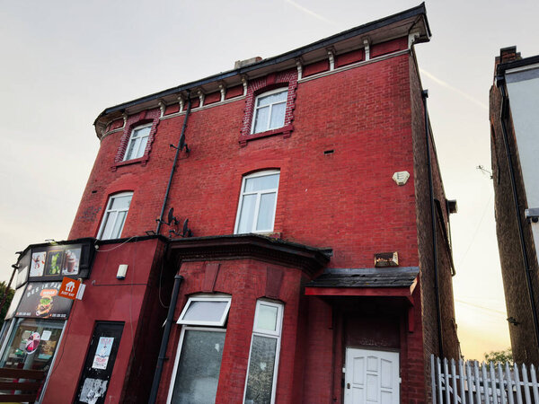 Манчестер, Великобритания - 16 сентября 2025 года: Историческое здание из красного кирпича с магазином, расположенное в Манчестере, Великобритания.