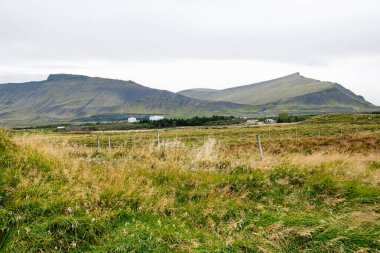 İzlanda 'nın geniş arazi manzarası gösterişli otlak düzlükleri, yüksek dağlar ve dağınık evler