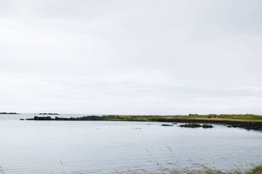 İzlanda 'nın güzel doğal manzarası bulutlu bir gökyüzünün altında sakin sular..
