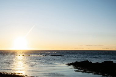 İzlanda 'nın güneşli kıyı şeridi sakin suları ve alacakaranlıkta sakin bir atmosferi ön plana çıkarıyor..