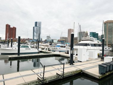 Baltimore, Maryland, ABD - 10 Nisan 2025: Baltimore, ABD 'de şehir manzaralı bir limana demirlemiş teknelerin manzarası.