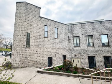 Baltimore, Maryland, ABD - 10 Nisan 2025: Baltimore, ABD 'de tuğla duvarlar, yeşillik ve şehir çevresi sergilenen çağdaş bina.