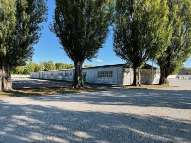 Dachau, Almanya - 29 Eylül 2022: Almanya 'daki Dachau toplama kampında ağaçlarla çevrili tarihi bir bina