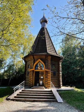 Dachau, Almanya - 29 Eylül 2022: Dachau Toplama Kampı 'ndaki ahşap Rus Ortodoks kilisesi açık mavi gökyüzü altında yeşil yapraklı