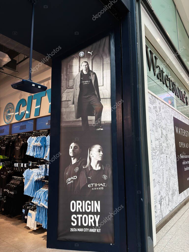 Manchester, UK - September 17, 2025: Promotional poster and Manchester City merchandise inside a shop in Manchester, featuring football gear and club branding.