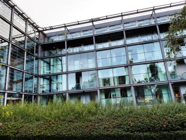 İngiltere 'de cam dış yüzeyler ve verimli peyzajlar içeren çağdaş mimari..