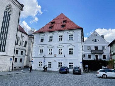 Eichstatt, Almanya - 22 Eylül 2022: Soluk mavi konak, kırmızı çatı, kaldırım taşı meydan ve Eichstatt 'ta park halindeki arabalarla dolu pitoresk bir Alman sokak sahnesi.