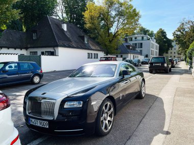 Münih, Almanya - 23 Eylül 2022: Parlak Rolls Royce Wraith tarzı lüks bir araba Almanya 'da ağaçlık bir cadde boyunca park edilmiş..