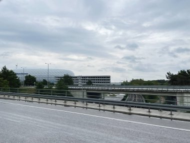 Münih, Almanya - 24 Eylül 2022: Otoyol köprüsü, demiryolu altgeçidi ve yakınlarındaki modern stadyumu olan şehir Almanya sahnesi.