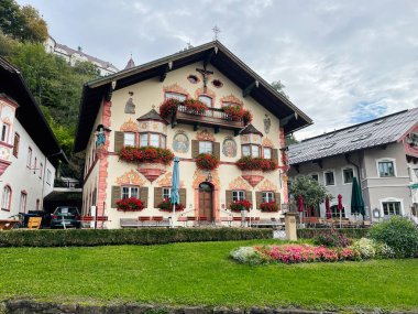Neubeuern, Almanya - 25 Eylül 2022: Bavyera 'da boyalı cepheleri, çiçek kutuları ve açık hava oturma yerleri olan dekoratif bir Alman evi.