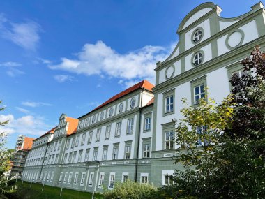 Furstenfeldbruck, Almanya - 26 Eylül 2022: Bir tepe boyunca zarif Alman Furstenfeldbruck mimarisi, dekoratif pencereler ve parlak kırmızı bir çatı.