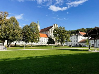Furstenfeldbruck, Almanya - 26 Eylül 2022: Furstenfeldbruck 'ta aydınlık bir gün, Almanya' da bir katedral, beyaz binalar, ağaçlar ve görülebilir otlak alan.