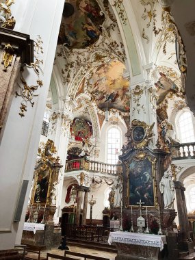 Andechs, Almanya - 27 Eylül 2022: Yaldızlı barok dekorasyonlar, fresk tavanlar ve süslü sunaklar içeren lüks Alman kilisesi iç mimarisi. 