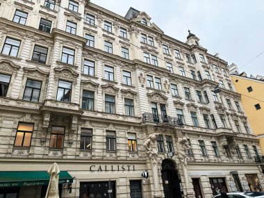 Viyana, Avusturya - 22 Ekim 2024: Avusturya 'nın Viyana kentinde kalabalık bir Avrupa caddesinde Merkez Hamamın dekoratif özellikleri ve dükkan cepheleriyle süslenmesi.