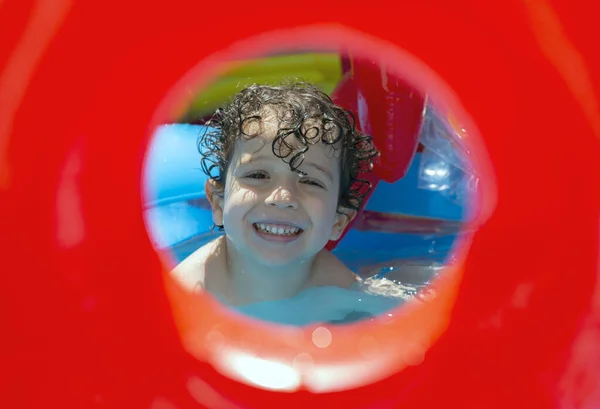 Boy playing and having fun in inflatable pool at home