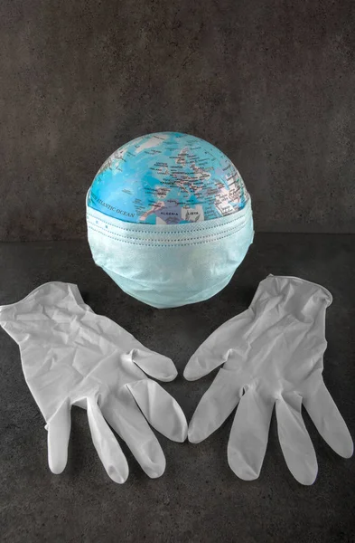 Dünya küresi cerrahi maskeli, lateks koruma eldivenli.