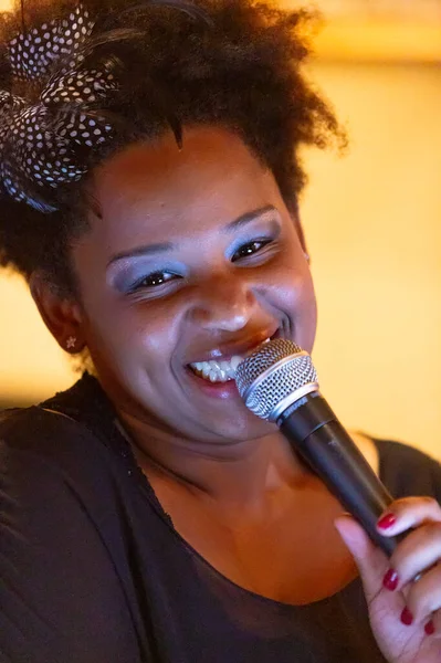 Güzel siyah şarkıcı kız, canlı performans sergiliyor.