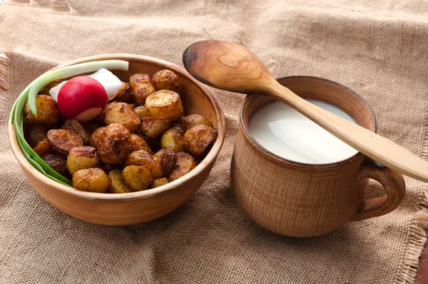 rural food, composition. Ukrainian national food. still life, concept. young fried potatoes in clay plate. mug of milk.