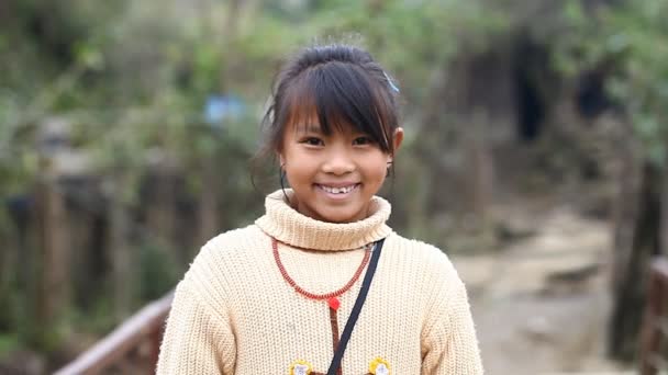 Sapa, Vietnam - November 30, 2016 : A little girl from the ethnic group of Hmong poses the foreigner for the camera. Children often pose for this purpose to earn reward or to sell the souvenirs. — Stock Video