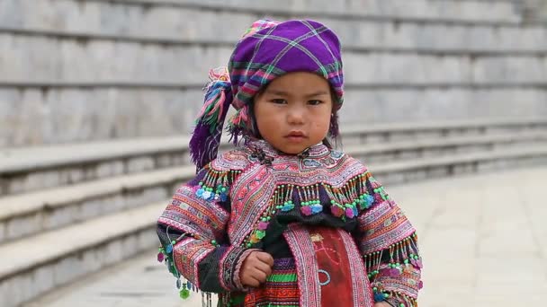 越南萨帕-2016年11月30日: 一个来自苗族民族的小女孩的民族服装。在游客面前摆姿势, 卖纪念品是苗族的主要收入来源之一。 — 图库视频影像
