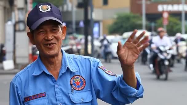 Ho Chi Minh City, Vietnã-janeiro 11,2017: Uma reportagem em vídeo nas ruas de Saigão. Um retrato de um guarda vietnamita amigável que está feliz em ver um estrangeiro de aparência europeia . — Vídeo de Stock