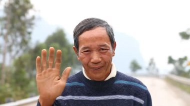 Phong Nha, Vietnam-Aralık 12,2016: Kolay yetişkin Vietnamca samimi ve dostça ağırlıyor başka bir ülkeye yolcusu. Vietnamca çok açık ve samimi insanlar