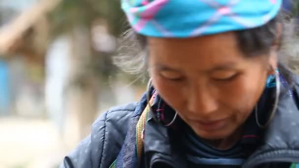 A Sapa, Vietnam - November 30-án, 2016: Egy nő, egy nemzeti ruha Hmong etnikai csoportból. A turisták előtt pózol és ajándéktárgyak értékesítése az egyik a fő bevételi forrását Hmong — Stock videók