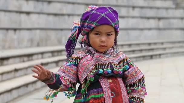 Sapa, Vietnam - 30 de noviembre de 2016: Una niña del grupo étnico de Hmong con un disfraz nacional. Posar ante los turistas y vender recuerdos es una de las principales fuentes de ingresos para Hmong. — Vídeos de Stock