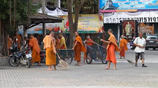 Chiang Mai, Thailandia-14 febbraio 2017: Un gruppo di giovani monaci buddisti pulisce il territorio del loro monastero dalle foglie cadute. La vita dei monaci thailandesi . — Video Stock