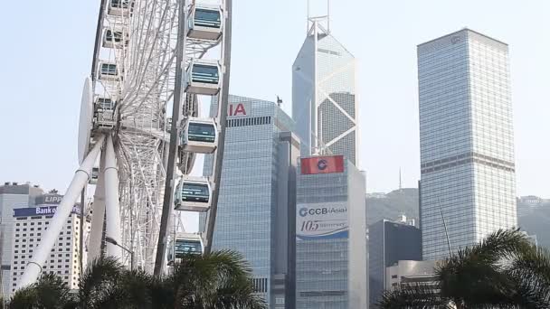 HONG KONG, HONG KONG - ABRIL 10,2017: Ferris wheel and skyscrapers Hong Kong. Hong Kong é uma das megacidades financeiras e turísticas mais desenvolvidas do mundo . — Vídeo de Stock