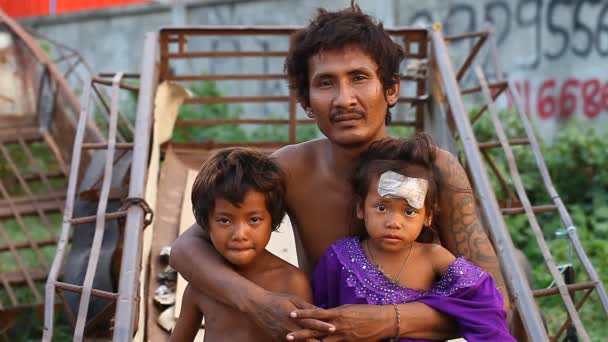Siam Reap, Cambodia - 14 januari 2017: En hemlös narkoman bor med sin unga barn i en spontan hus av lådor och konstruktion skräp. — Stockvideo