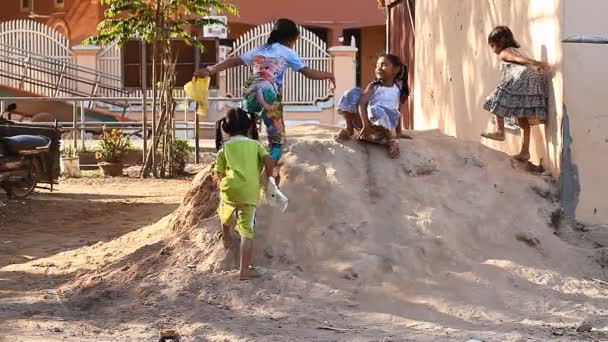 Siam Reapu, Kambodža - 14. ledna 2017: Děti žijící v chudé vesnici jezdit na kartony a plastové sáčky se skluzavkou jílu. Těžké dětství dětí žijících v chudinské čtvrti a chudé vesnice z Kambodže — Stock video