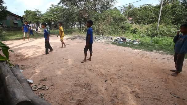 Siam Reapu, Kambodža - 13. ledna 2017: Kambodžské děti hrají fotbal na silnici v jejich chudé vesnici. Život v chudých osadách a slumů v Kambodži — Stock video