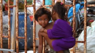 Siam Reap, Kamboçya - 14 Ocak 2017: Boş kutular ve inşaat enkaz bir evde yaşayan genç kız kardeşi ile bir evsiz çocuk.