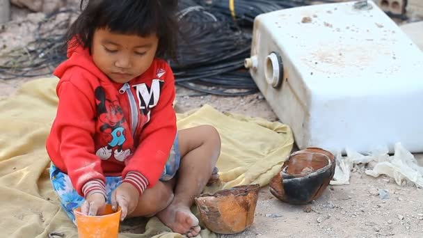 Siam Reap, Cambodia - 14 januari 2017: En liten kambodjanska flicka leker bredvid sopor och avfall. Livet i slummen och fattiga byar i Kambodja — Stockvideo