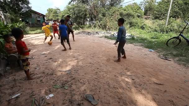 Siam reap, Kambodscha - 13. Januar 2017: Kambodschanische Kinder spielen auf der Straße in ihrem armen Dorf Fußball. Leben in armen Siedlungen und Slums in Kambodscha — Stockvideo