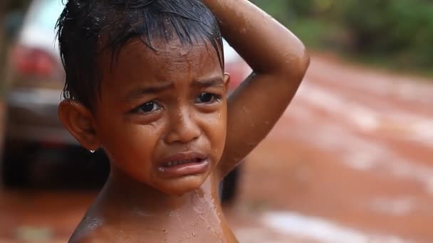 Siam Reap, Kambodja - 13 januari, 2017: Porträtt av en gråtande pojke. En liten kambodjanska pojke från en fattig by i regnet . — Stockvideo