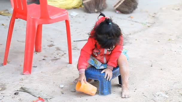 Siam arat, Kambodzsa - 2017. január 14.: Egy kis kambodzsai lány játszik, szemét és hulladék. Élet a nyomornegyedek és a szegény falvakban, Kambodzsa — Stock videók