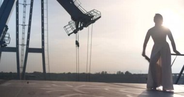 Güzel genç kız jimnastikçi nazikçe ve plastikler gün batımı karşı hareket