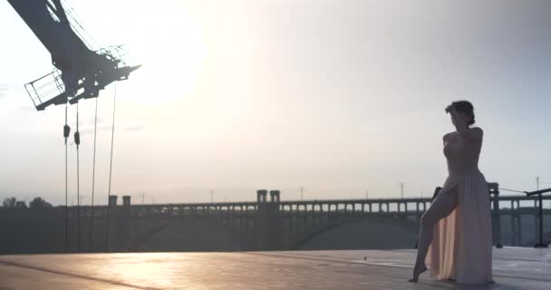 Het meisje is een professionele gymnast met een mooie sport figuur doen sierlijke acrobatische bewegingen. — Stockvideo